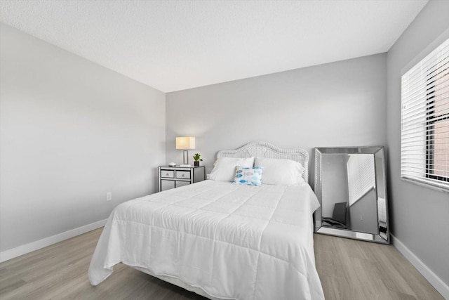 bedroom featuring multiple windows and light wood-type flooring