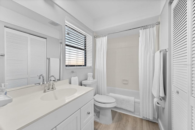 full bathroom featuring vanity, wood-type flooring, shower / tub combo with curtain, and toilet