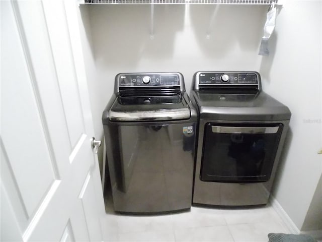 washroom with light tile patterned flooring and washer and dryer