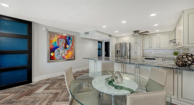 dining space with sink, parquet floors, and ceiling fan