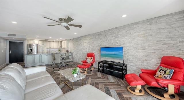 living room featuring ceiling fan and dark parquet floors