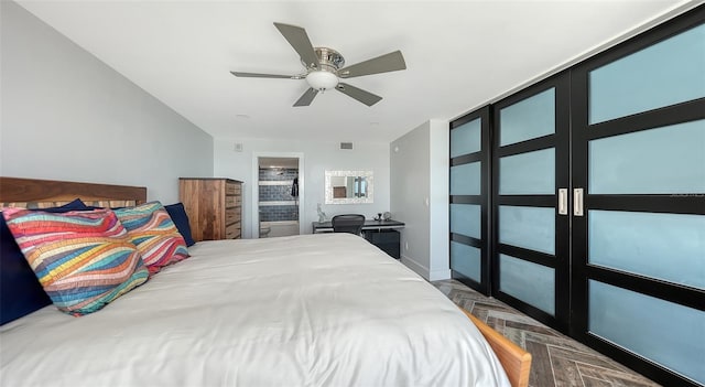 bedroom featuring parquet flooring, ceiling fan, and ensuite bath