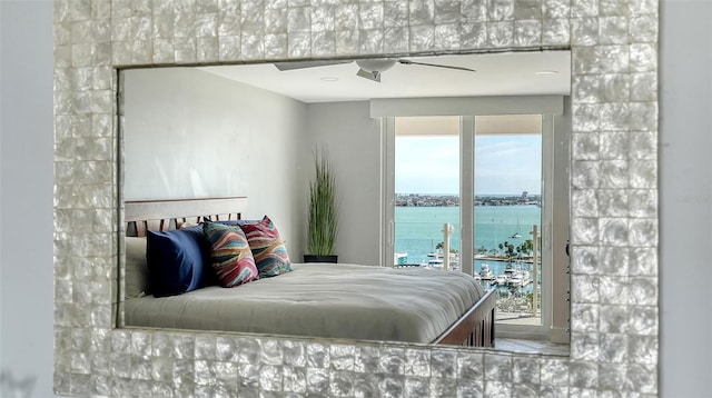 bedroom featuring a water view and ceiling fan