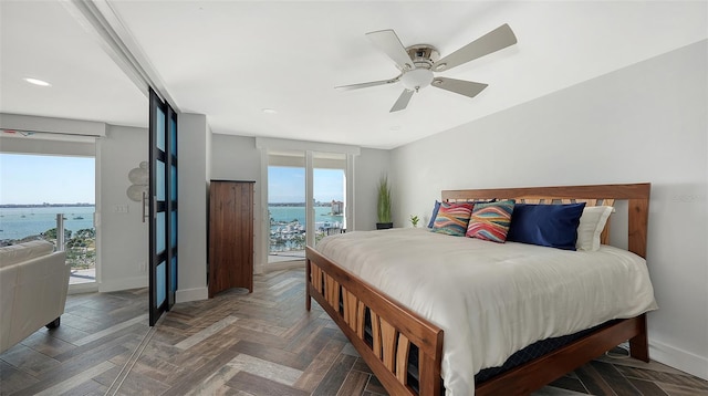 bedroom featuring a water view, ceiling fan, dark parquet floors, and access to outside