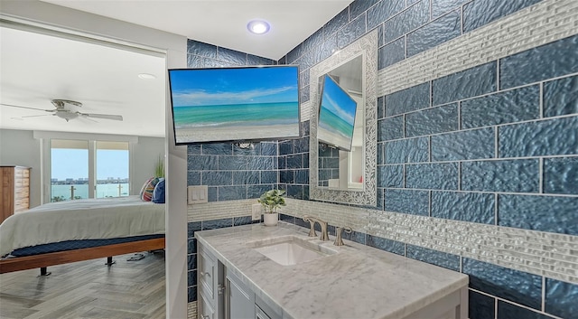 bathroom with ceiling fan, tile walls, vanity, parquet floors, and decorative backsplash