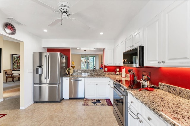 kitchen featuring appliances with stainless steel finishes, a sink, visible vents, and white cabinetry