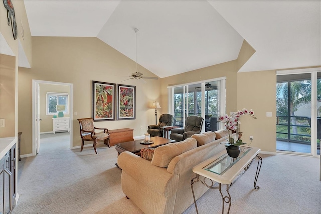 living area featuring light carpet, high vaulted ceiling, a ceiling fan, and baseboards