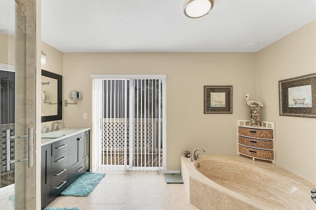 bathroom featuring tile patterned flooring, vanity, and a bath