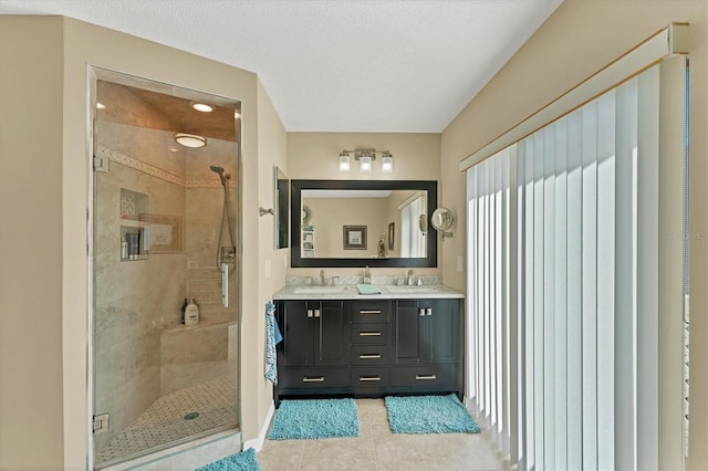 full bathroom featuring a stall shower, tile patterned flooring, and a sink