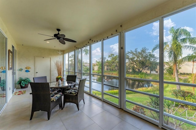 sunroom featuring a water view and ceiling fan