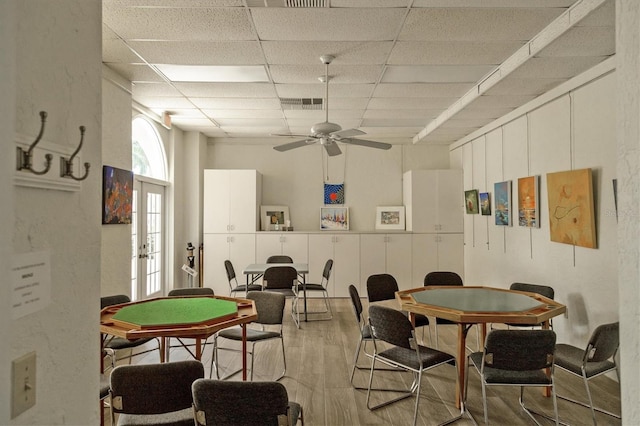 dining room with visible vents, a ceiling fan, french doors, a paneled ceiling, and light wood-style floors