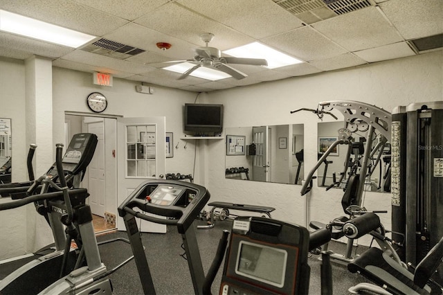 workout area with a ceiling fan, a paneled ceiling, visible vents, and a textured wall