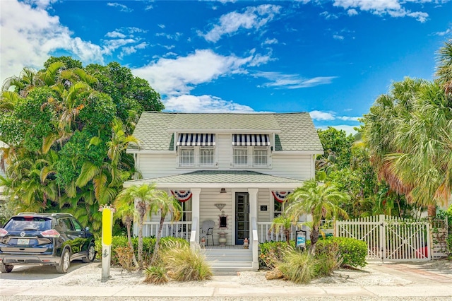 view of front of home featuring a porch, a shingled roof, fence, and a gate