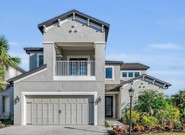 view of front facade featuring a balcony, a garage, concrete driveway, and stucco siding