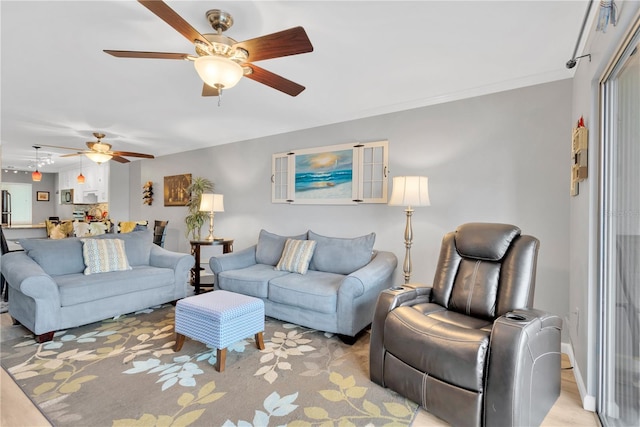 living room with ornamental molding and ceiling fan