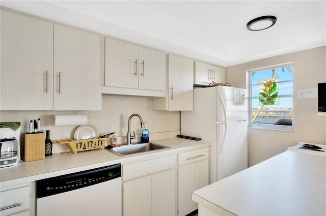 kitchen featuring dishwasher, white fridge, and sink