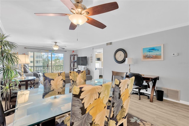 dining space featuring ornamental molding and light hardwood / wood-style floors