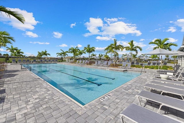 pool with a patio area and fence