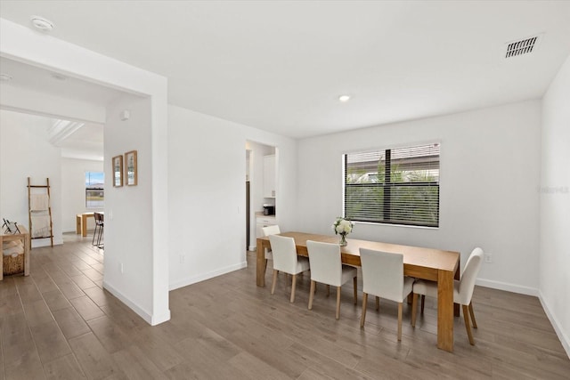 dining space featuring light wood finished floors, visible vents, and baseboards