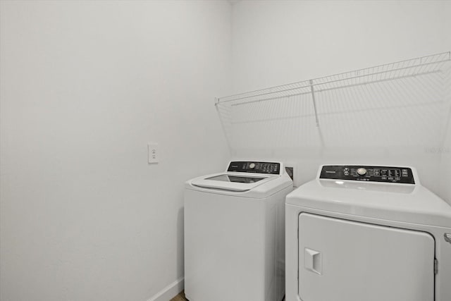 laundry area featuring laundry area, washing machine and dryer, and baseboards