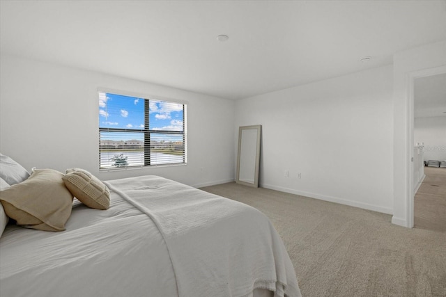 bedroom featuring light colored carpet and baseboards