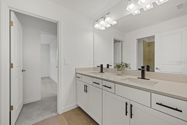 bathroom featuring visible vents, a sink, baseboards, and double vanity