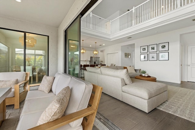 living area with dark wood-type flooring and a towering ceiling