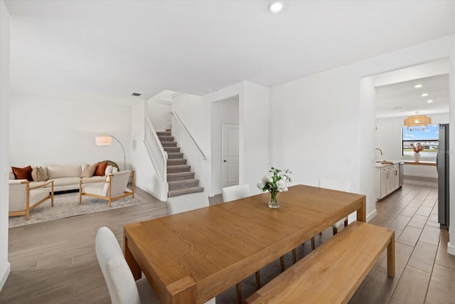 dining area featuring light wood-type flooring, stairway, and recessed lighting