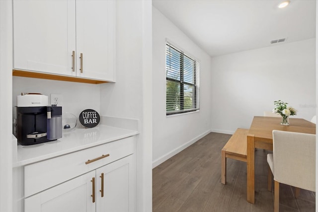 dining room featuring baseboards, visible vents, and wood finished floors