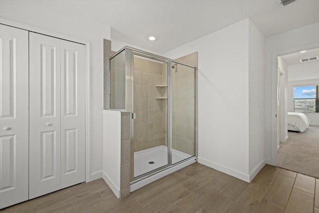 ensuite bathroom with a stall shower, ensuite bath, visible vents, and a closet