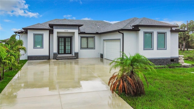 prairie-style house featuring a front lawn and a garage