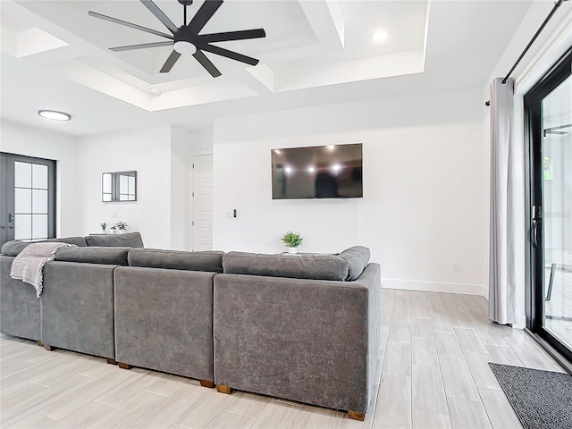 living room featuring ceiling fan, a tray ceiling, and coffered ceiling