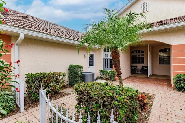 entrance to property with central AC unit and a patio