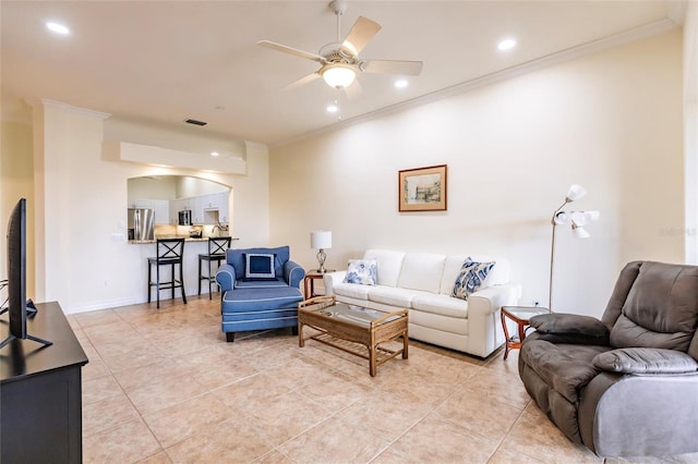 tiled living room with ceiling fan and ornamental molding