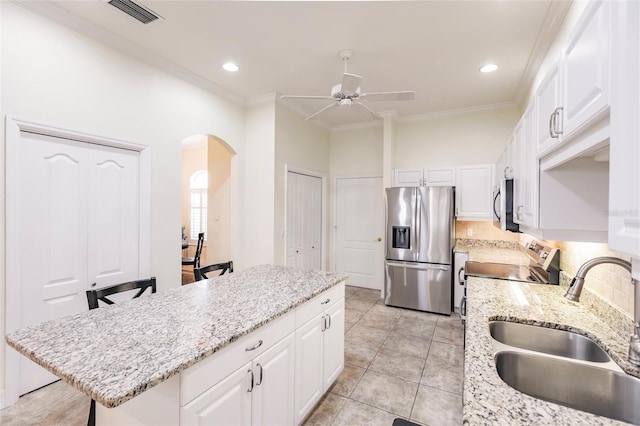 kitchen featuring a kitchen island, sink, crown molding, white cabinetry, and appliances with stainless steel finishes