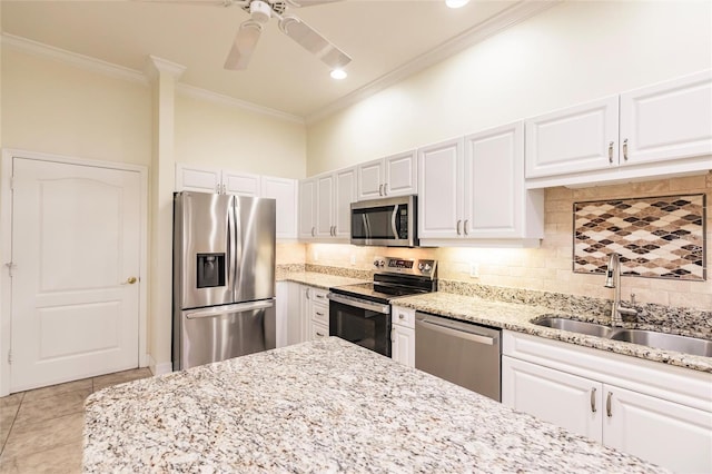 kitchen featuring stainless steel appliances, backsplash, ornamental molding, white cabinets, and sink