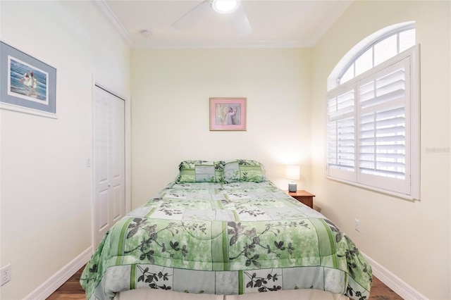 bedroom featuring ceiling fan, a closet, crown molding, and multiple windows