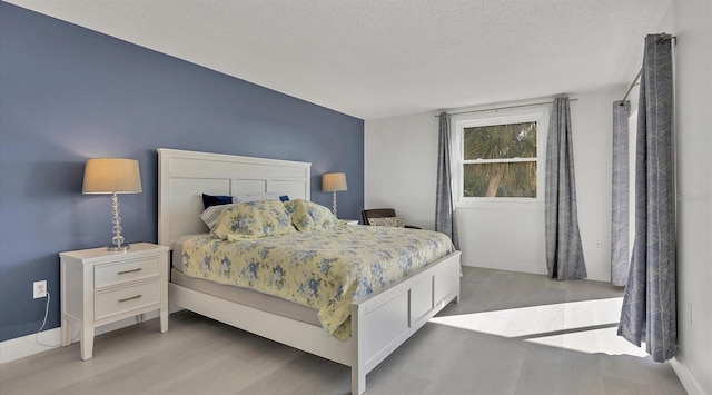 bedroom with light wood-type flooring and a textured ceiling