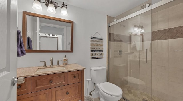 bathroom featuring toilet, vanity, and an enclosed shower