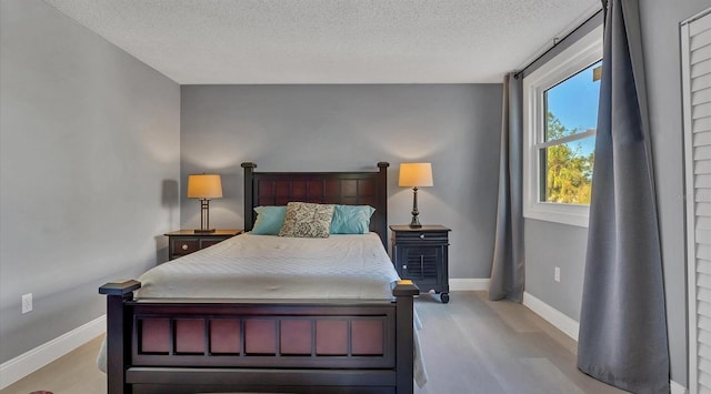 bedroom with light wood-type flooring and a textured ceiling