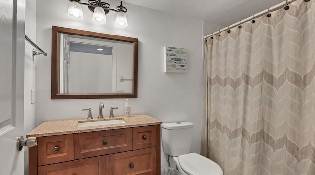 bathroom featuring toilet, vanity, and walk in shower