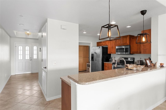 kitchen featuring light tile patterned floors, kitchen peninsula, pendant lighting, stainless steel appliances, and light stone countertops