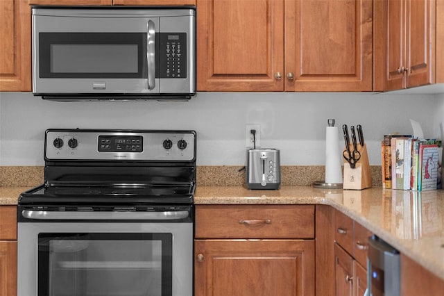 kitchen featuring light stone counters and appliances with stainless steel finishes