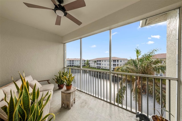 sunroom / solarium with a water view and ceiling fan