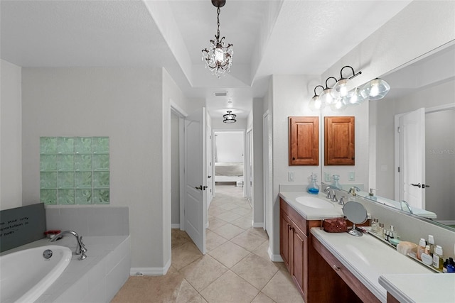 bathroom with an inviting chandelier, tile patterned floors, vanity, and tiled bath