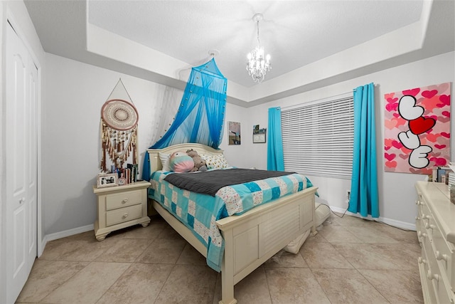 tiled bedroom with an inviting chandelier, a raised ceiling, and a textured ceiling