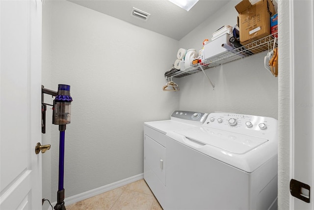 clothes washing area with light tile patterned floors and washing machine and dryer