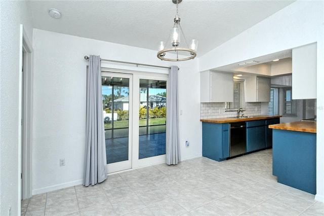 kitchen with backsplash, pendant lighting, white cabinetry, blue cabinets, and wood counters