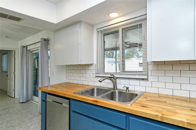 kitchen featuring wooden counters, decorative backsplash, dishwasher, white cabinets, and sink