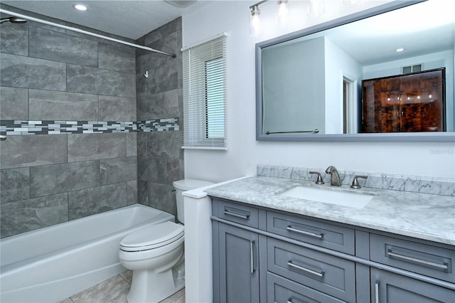 full bathroom featuring tiled shower / bath combo, vanity, toilet, and tile patterned flooring